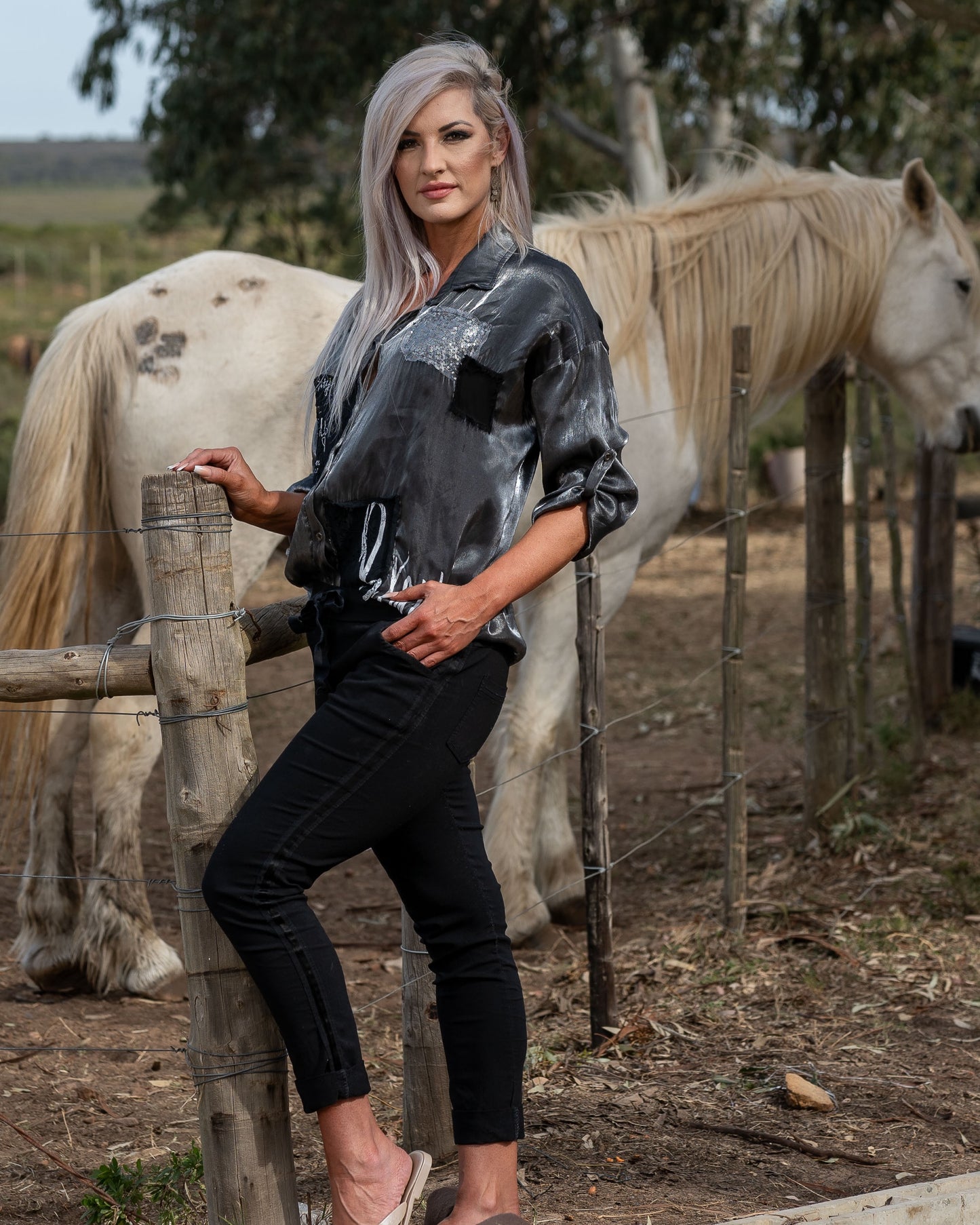 What a SHOWSTOPPER piece this is - and our fave from this collection! A&nbsp;sleek collar and a lustrous finish that adds a touch of sophistication to your look. The standout details include sequin patch accents and intricate anglaise embroidery, giving the shirt a unique texture and visual appeal. The addition of white script further enhances its modern edge, making this shirt a perfect choice for those who love to blend tradition with a touch of sparkle. Ideal for both day and night, this shirt is a versa