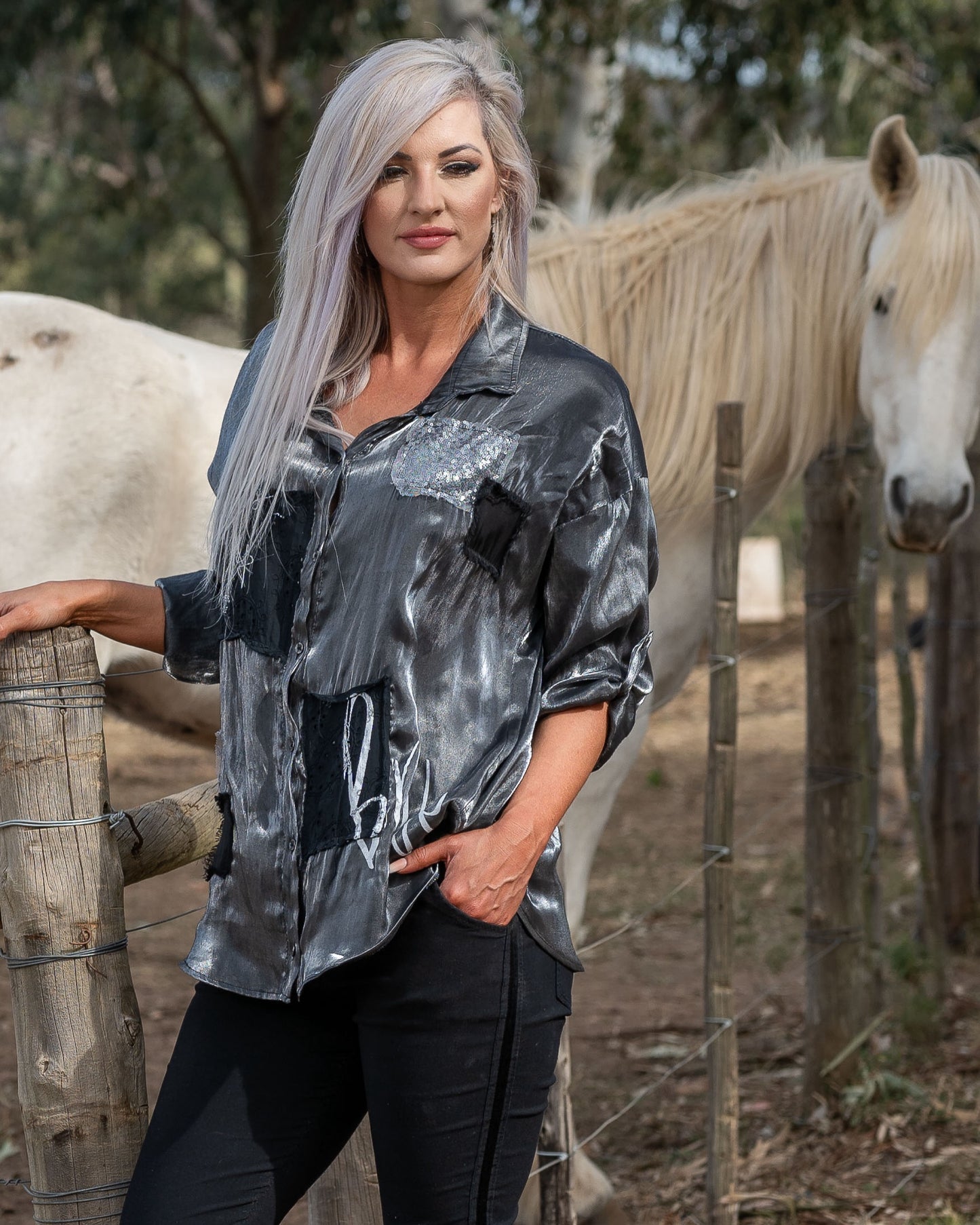 What a SHOWSTOPPER piece this is - and our fave from this collection! A&nbsp;sleek collar and a lustrous finish that adds a touch of sophistication to your look. The standout details include sequin patch accents and intricate anglaise embroidery, giving the shirt a unique texture and visual appeal. The addition of white script further enhances its modern edge, making this shirt a perfect choice for those who love to blend tradition with a touch of sparkle. Ideal for both day and night, this shirt is a versa