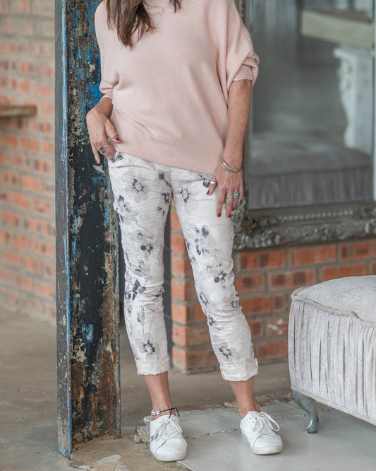 These pants boast a captivating floral print that evokes the romance of a sun-drenched Tuscan garden. The drawstring waist ensures a perfect fit while offering a touch of casual charm, making them versatile for both casual outings and sophisticated events. With their flowing silhouette and delicate detailing, these pants effortlessly elevate any ensemble, promising a blend of style and ease that is timeless