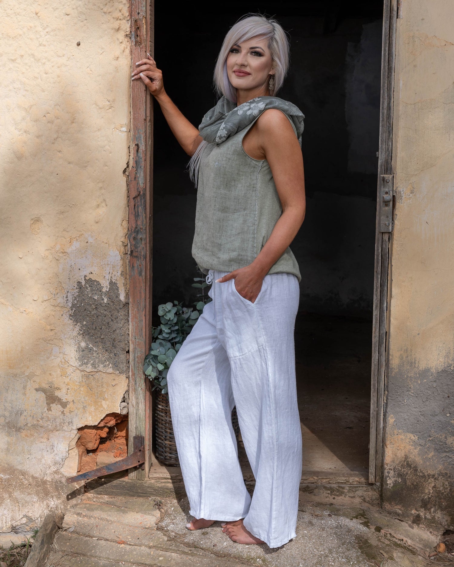 Crafted from 100% linen, this tank style cami offers a breathable, lightweight feel that keeps you cool and comfortable. The silver script detail adds a touch of elegance, while the decorative pocket provides a stylish accent. Finished with silver threading all around, this top exudes subtle glamour, making it ideal for both relaxed days and more polished occasions. Whether paired with your favorite jeans or layered under a jacket, this cami is a versatile piece that adds a refined touch to any outfit