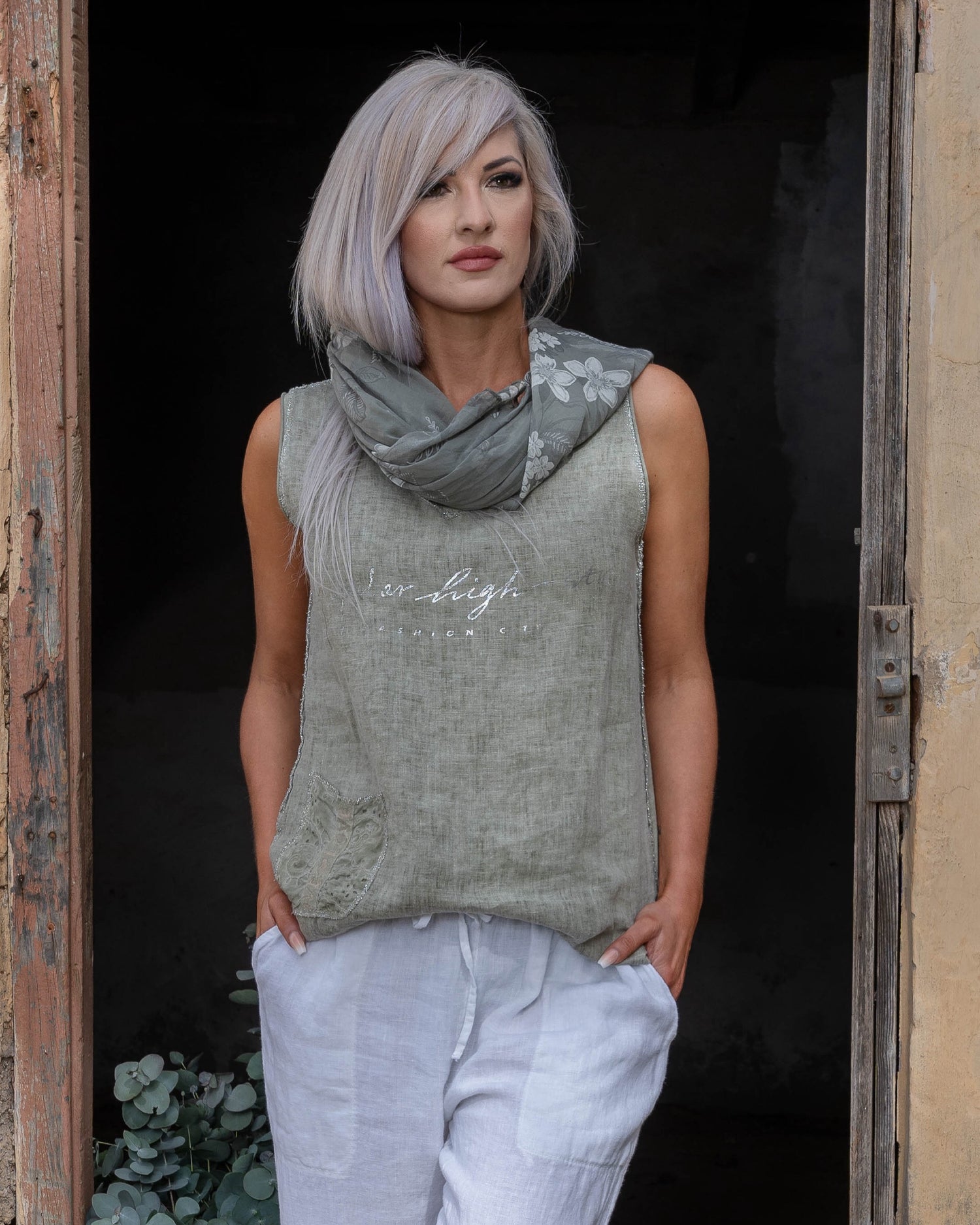 Crafted from 100% linen, this tank style cami offers a breathable, lightweight feel that keeps you cool and comfortable. The silver script detail adds a touch of elegance, while the decorative pocket provides a stylish accent. Finished with silver threading all around, this top exudes subtle glamour, making it ideal for both relaxed days and more polished occasions. Whether paired with your favorite jeans or layered under a jacket, this cami is a versatile piece that adds a refined touch to any outfit