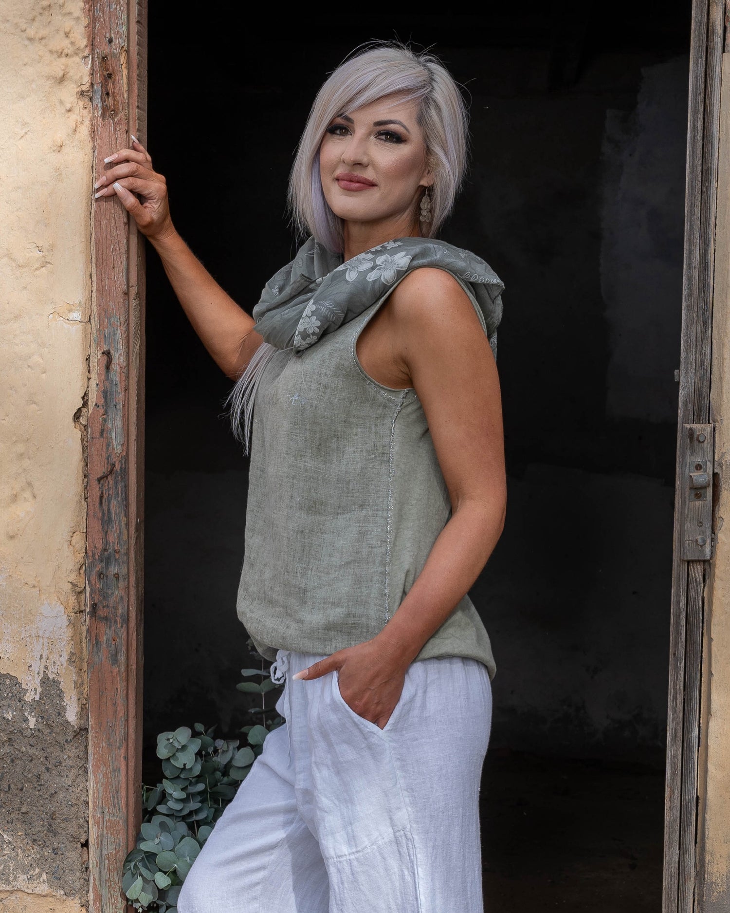 Crafted from 100% linen, this tank style cami offers a breathable, lightweight feel that keeps you cool and comfortable. The silver script detail adds a touch of elegance, while the decorative pocket provides a stylish accent. Finished with silver threading all around, this top exudes subtle glamour, making it ideal for both relaxed days and more polished occasions. Whether paired with your favorite jeans or layered under a jacket, this cami is a versatile piece that adds a refined touch to any outfit