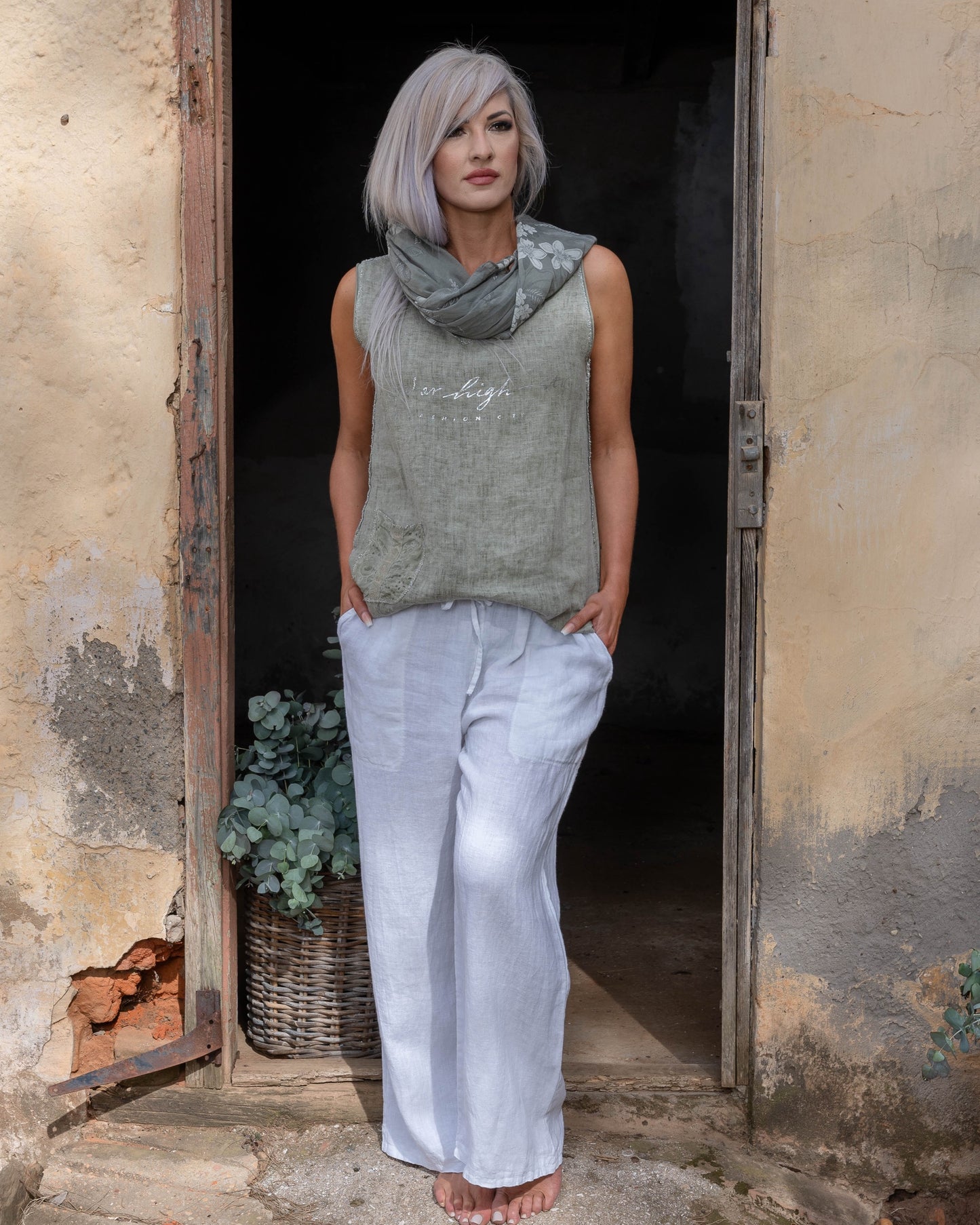 Crafted from 100% linen, this tank style cami offers a breathable, lightweight feel that keeps you cool and comfortable. The silver script detail adds a touch of elegance, while the decorative pocket provides a stylish accent. Finished with silver threading all around, this top exudes subtle glamour, making it ideal for both relaxed days and more polished occasions. Whether paired with your favorite jeans or layered under a jacket, this cami is a versatile piece that adds a refined touch to any outfit