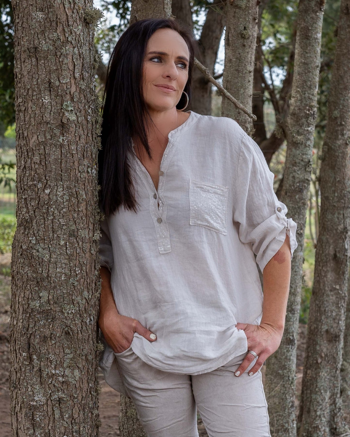 One of our all time favourites - now in Linen!&nbsp;This top features a dazzling sequin insert that adds a touch of sparkle, complemented by wooden button-down detailing that brings a natural, earthy charm. A sequin pocket enhances the visual appeal with a subtle shimmer. The 3/4 sleeves come with a convenient pull-up tab, allowing you to adjust your look to suit any occasion. Crafted from pure linen, this top combines breathability with a chic design