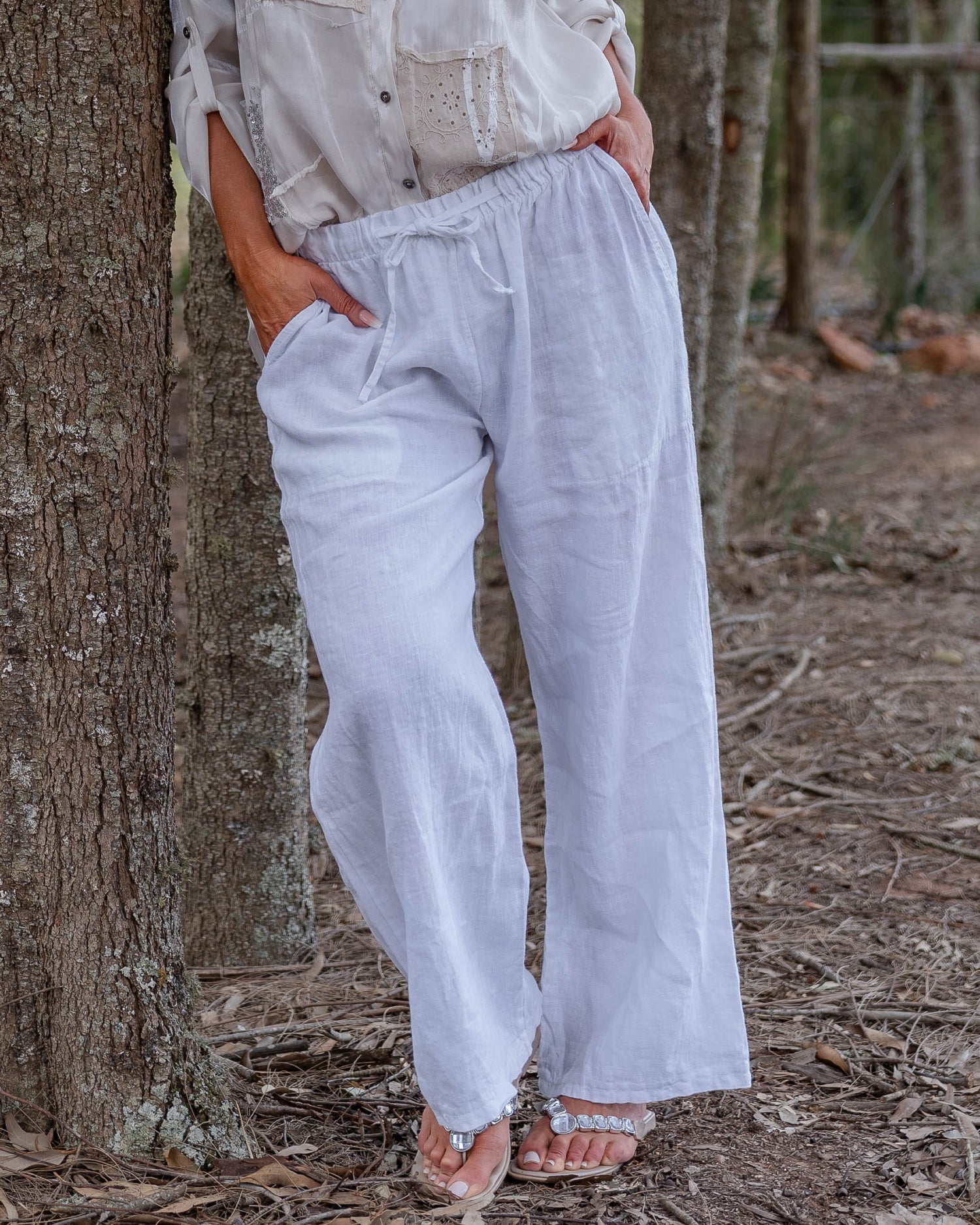 The perfect blend of comfort and style. These high-waisted pants feature an elasticated waistband with a functional drawstring. The slight wide-leg design creates a relaxed yet elegant silhouette, making these pants a versatile choice for any occasion.&nbsp;Designed with deep side pockets, these pants are as practical as they are chic, offering ample space to carry your essentials. Crafted from pure linen, they provide a breathable and lightweight feel, keeping you cool and comfortable throughout the day